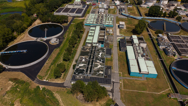 Aerial view of a wastewater treatment plant with circular sedimentation tanks and aeration basins surrounded by greenery in Milan Lombardy Italy. Aerial view of a wastewater treatment plant with circular sedimentation tanks and aeration basins surrounded by greenery in Milan Lombardy Italy.