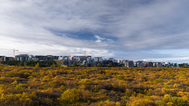 Aerial view of an apartment complex under construction surrounded by autumn vegetation in Iceland. Aerial view of an apartment complex under construction surrounded by autumn vegetation in Iceland.