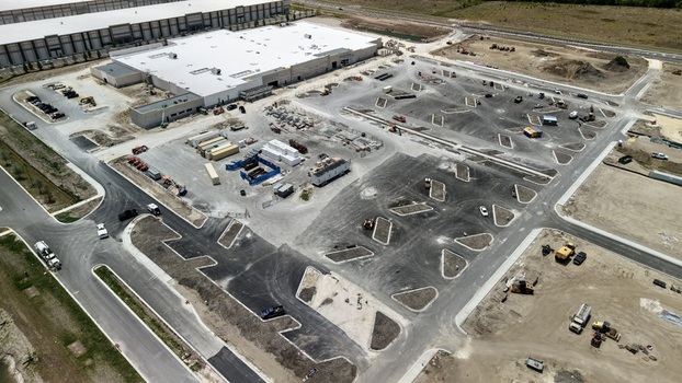 Aerial view of the construction site at Foundry Lane featuring a large warehouse building and a newly paved parking lot in World Golf Village Florida United States.