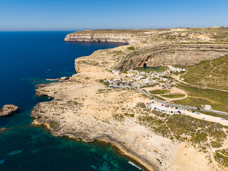 Aerial view of Dwejra Bay with rugged limestone cliffs and the turquoise Mediterranean sea in Gozo Region Malta. Aerial view of Dwejra Bay with rugged limestone cliffs and the turquoise Mediterranean sea in Gozo Region Malta.