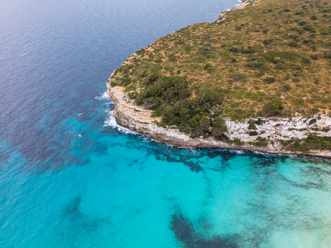 Aerial view of the turquoise waters and rocky cliffs of Cala Mendia bay Cala Mendia Illes Balears Spain. Aerial view of the turquoise waters and rocky cliffs of Cala Mendia bay Cala Mendia Illes Balears Spain.
