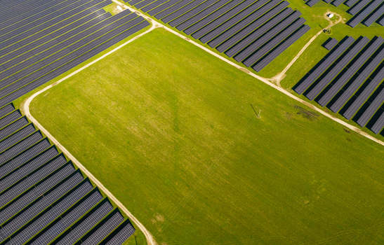 Aerial view of a large solar farm with rows of photovoltaic panels arranged in a green field in Pomeranian Voivodeshi Poland. Aerial view of a large solar farm with rows of photovoltaic panels arranged in a green field in Pomeranian Voivodeshi Poland.