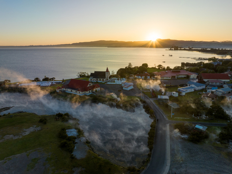 Aerial view of the sun s golden glow kissing the steaming shores near the church Rotorua Bay of Plenty Region New Zealand. Aerial view of the sun s golden glow kissing the steaming shores near the church Rotorua Bay of Plenty Region New Zealand.