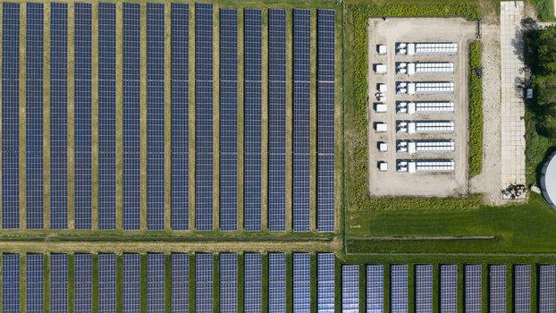 Aerial view of a large solar farm with rows of photovoltaic panels and an electrical substation in Wanneperveen Overijssel Netherlands.