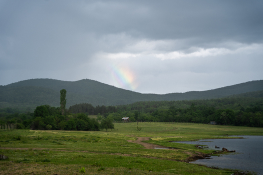 View of a rainbow over the green hills and lake near the Zhrebchevo Reservoir in Sliven Bulgaria. View of a rainbow over the green hills and lake near the Zhrebchevo Reservoir in Sliven Bulgaria.