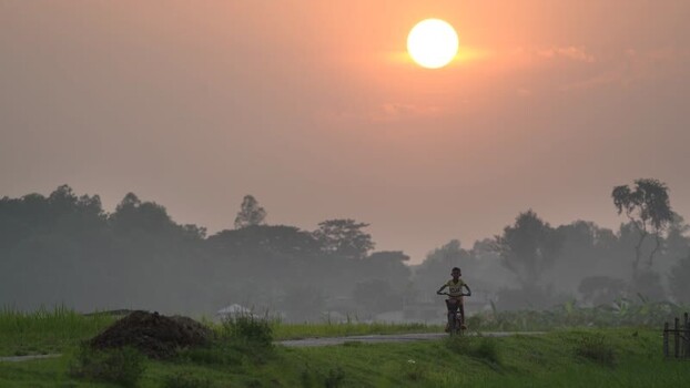 View of a boy riding a bicycle at sunset in Bogura Bangladesh. View of a boy riding a bicycle at sunset in Bogura Bangladesh.