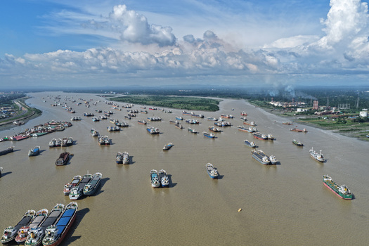 Aerial view of Karnaphuli River filled with numerous cargo ships and vessels navigating the waterway in Chattogram Chattogram Division Bangladesh.