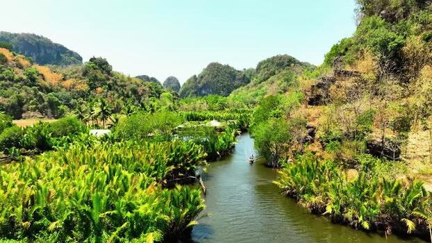 Aerial view of a boat on a river through karst hills in Maros Indonesia. Aerial view of a boat on a river through karst hills in Maros Indonesia.