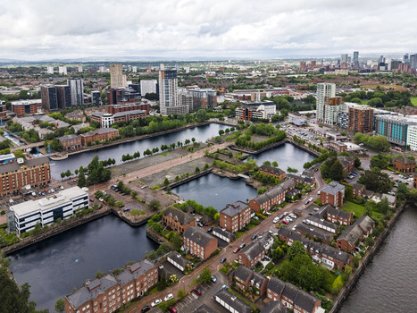 Aerial view of MediaCityUK and the surrounding Salford Quays area featuring modern apartment buildings brick residential blocks and calm waterways in Salford England United Kingdom. Aerial view of MediaCityUK and the surrounding Salford Quays area featuring modern apartment buildings brick residential blocks and calm waterways in Salford England United Kingdom.