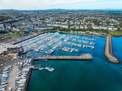Aerial view of Bangor Harbour and Town featuring numerous sailboats docked in the marina surrounded by the coastal town buildings and green hills in Bangor Northern Ireland United Kingdom.