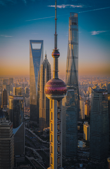 Aerial view of the Lujiazui financial district featuring the Oriental Pearl Tower and Shanghai Tower during golden hour in Shanghai Shanghai China.