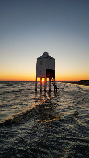 Aerial view of the Burnham on Sea Low Lighthouse on stilts in the water at sunset with waves reflecting the golden light in Burnham on Sea England United Kingdom. Aerial view of the Burnham on Sea Low Lighthouse on stilts in the water at sunset with waves reflecting the golden light in Burnham on Sea England United Kingdom.