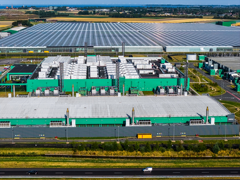 Aerial view of Agriport A7 a large industrial data center complex with green buildings and expansive glass greenhouses situated near a highway in Middenmeer Noord Holland Netherlands. Aerial view of Agriport A7 a large industrial data center complex with green buildings and expansive glass greenhouses situated near a highway in Middenmeer Noord Holland Netherlands.