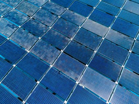 Aerial view of the SolarSea floating solar power plant with blue photovoltaic panels arranged in a geometric grid over the ocean at Dharavandhoo Baa Atoll Maldives. Aerial view of the SolarSea floating solar power plant with blue photovoltaic panels arranged in a geometric grid over the ocean at Dharavandhoo Baa Atoll Maldives.