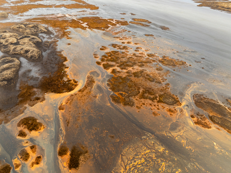 Aerial view of the intricate river delta and volcanic landscape with mossy terrain and sediment patterns in Iceland. Aerial view of the intricate river delta and volcanic landscape with mossy terrain and sediment patterns in Iceland.