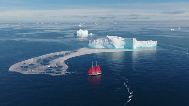 Aerial view of a sailboat with red sails in Greenland. Aerial view of a sailboat with red sails in Greenland.