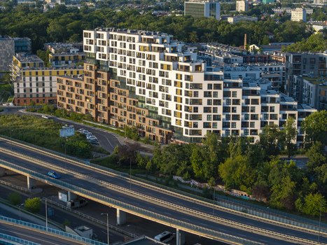 Aerial view of a modern residential apartment building with a stepped terraced design and white and brown facade situated near a highway in Krakow Lesser Poland Voivode Poland.