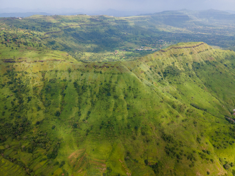 Aerial view of Kaas plateau featuring lush green rolling hills terraced slopes and vibrant vegetation in Satara Maharashtra India.