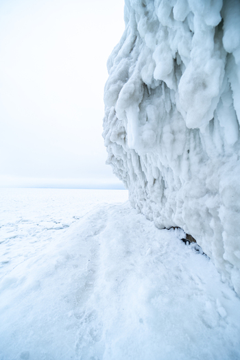 View of the ice covered Molenfeuer Sassnitz lighthouse structure with thick icicles and frozen surfaces along the Baltic Sea coast in Sassnitz Mecklenburg Vorpommern Germany.
