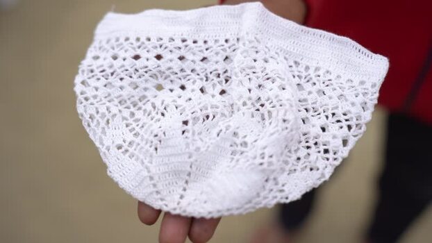 View of a white crocheted cap held in hand Bangladesh. View of a white crocheted cap held in hand Bangladesh.