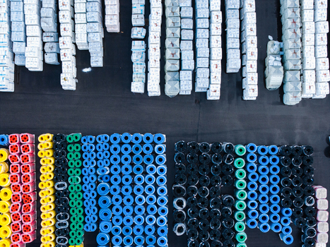 Aerial view of organized rows of colorful plastic pipes and stacked white industrial materials at a manufacturing facility in Jelgava Latvia. Aerial view of organized rows of colorful plastic pipes and stacked white industrial materials at a manufacturing facility in Jelgava Latvia.