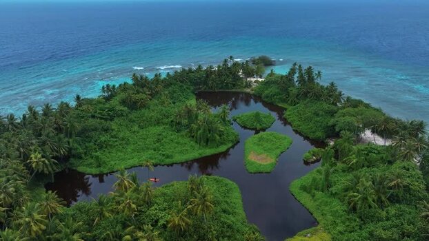 Aerial view of a tropical island with a dark inland lagoon Maldives. Aerial view of a tropical island with a dark inland lagoon Maldives.