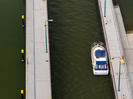 Aerial view of Schleuse Spandau with a small motorboat navigating the concrete lock chamber in Berlin Berlin Germany.
