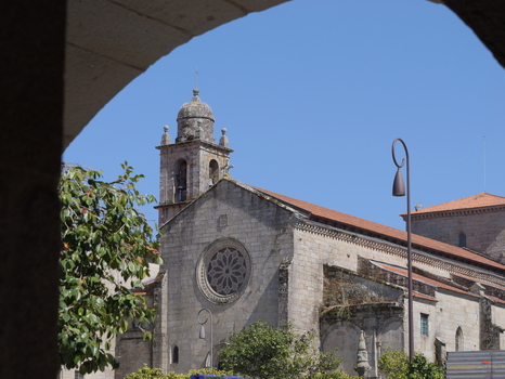 View of the Convento e Igrexa de San Francisco with its stone facade rose window and bell tower framed by an archway under a clear blue sky in Pontevedra Pontevedra Spain. View of the Convento e Igrexa de San Francisco with its stone facade rose window and bell tower framed by an archway under a clear blue sky in Pontevedra Pontevedra Spain.