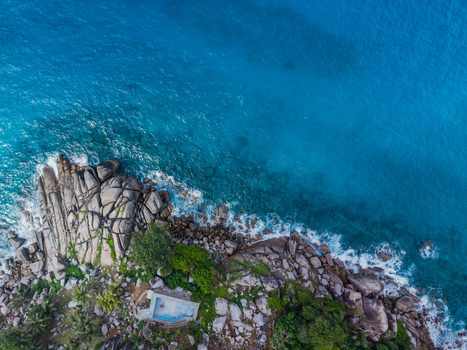 Aerial view of rugged coastline meets the turquoise sea with rocky outcrops and lush greenery contrasting against the vibrant ocean Vista do Mar Mahe Island Seychelles. Aerial view of rugged coastline meets the turquoise sea with rocky outcrops and lush greenery contrasting against the vibrant ocean Vista do Mar Mahe Island Seychelles.