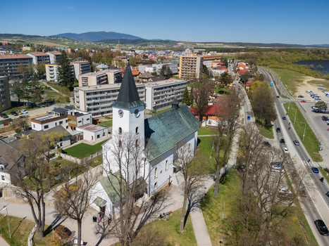 Aerial view of the Roman Catholic Church of Saints Simon and Jude with its white facade and black spire surrounded by urban buildings in Namestovo Zilina Region Slovakia. Aerial view of the Roman Catholic Church of Saints Simon and Jude with its white facade and black spire surrounded by urban buildings in Namestovo Zilina Region Slovakia.