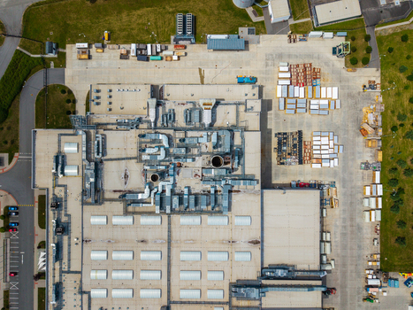 Aerial view of an industrial facility with rooftop ventilation systems skylights and a storage yard with containers in Zebrak Central Bohemian Region Czechia. Aerial view of an industrial facility with rooftop ventilation systems skylights and a storage yard with containers in Zebrak Central Bohemian Region Czechia.