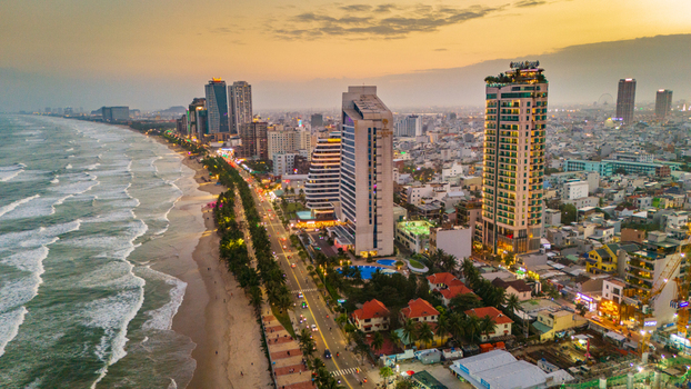 Aerial view of the coastal skyline at sunset featuring modern high rise hotels along the sandy beach with waves crashing on the shore Da Nang Vietnam. Aerial view of the coastal skyline at sunset featuring modern high rise hotels along the sandy beach with waves crashing on the shore Da Nang Vietnam.