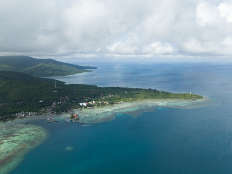 Aerial view of the island s lush greenery meeting the turquoise sea a coastal village nestled along the shore Karimunjawa Central Java Indonesia. Aerial view of the island s lush greenery meeting the turquoise sea a coastal village nestled along the shore Karimunjawa Central Java Indonesia.