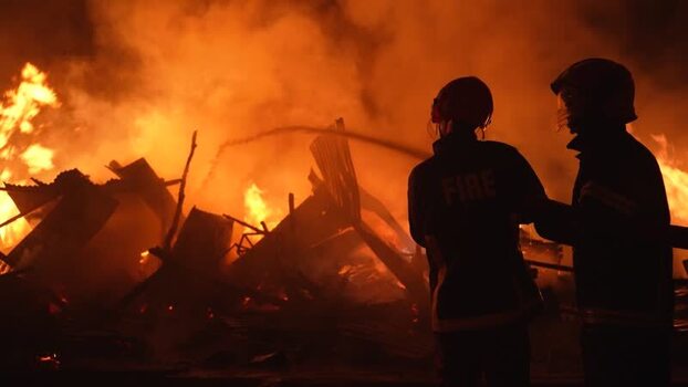 View of firefighters battling a large fire at night Bangladesh. View of firefighters battling a large fire at night Bangladesh.