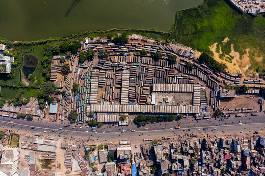 Aerial view of Gabtoli Bus Terminal with rows of parked buses corrugated roof structures and surrounding urban density in Dhaka Dhaka Division Bangladesh.