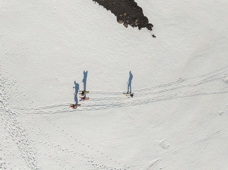 Aerial view of the south slope of Mount Etna with people skiing across the white snow and casting long shadows in Nicolosi Sicily Italy. Aerial view of the south slope of Mount Etna with people skiing across the white snow and casting long shadows in Nicolosi Sicily Italy.