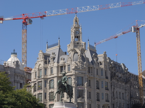 View of the statue of King Pedro IV in Praca da Liberdade with historic architecture and construction cranes in the background in Porto Porto District Portugal. View of the statue of King Pedro IV in Praca da Liberdade with historic architecture and construction cranes in the background in Porto Porto District Portugal.