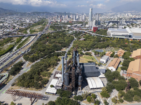 Aerial view of Fundidora Park featuring the historic Horno 3 blast furnace surrounded by greenery and industrial architecture with the Monterrey skyline Monterrey Nuevo Leon Mexico. Aerial view of Fundidora Park featuring the historic Horno 3 blast furnace surrounded by greenery and industrial architecture with the Monterrey skyline Monterrey Nuevo Leon Mexico.