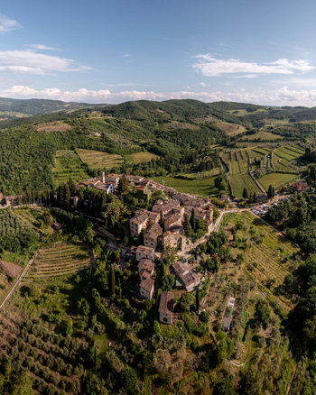 Aerial view of the historic hilltop village of Montefioralle surrounded by lush green vineyards olive groves and rolling hills in Montefioralle Tuscany Italy. Aerial view of the historic hilltop village of Montefioralle surrounded by lush green vineyards olive groves and rolling hills in Montefioralle Tuscany Italy.