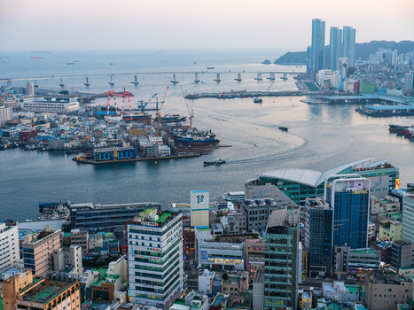 Busan South Korea 21 February 2026 Aerial view of Busan port featuring the Gwangan Bridge industrial cranes ships in the harbor and dense urban buildings under a soft sky. Busan South Korea 21 February 2026 Aerial view of Busan port featuring the Gwangan Bridge industrial cranes ships in the harbor and dense urban buildings under a soft sky.