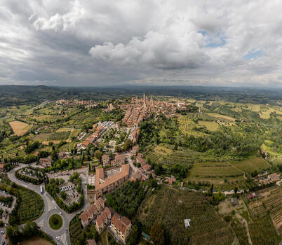 Aerial view of the medieval town of San Gimignano with its iconic stone towers surrounded by rolling hills vineyards and olive groves in San Gimignano Tuscany Italy. Aerial view of the medieval town of San Gimignano with its iconic stone towers surrounded by rolling hills vineyards and olive groves in San Gimignano Tuscany Italy.
