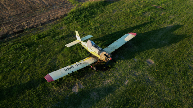 Serbia 03 September 2023 Aerial view of a small yellow agricultural aircraft parked on a grassy field.