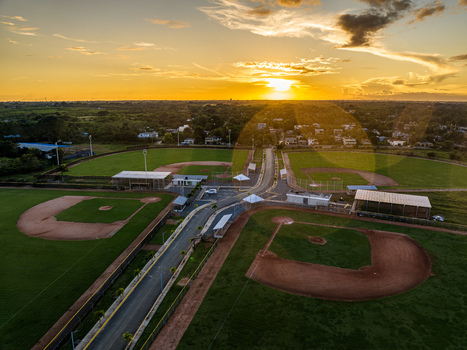 Aerial view of Quality Baseball Academy with baseball fields green grass and dirt infields under a golden sunset in San Antonio de Guerra Santo Domingo Province Dominican Republic. Aerial view of Quality Baseball Academy with baseball fields green grass and dirt infields under a golden sunset in San Antonio de Guerra Santo Domingo Province Dominican Republic.
