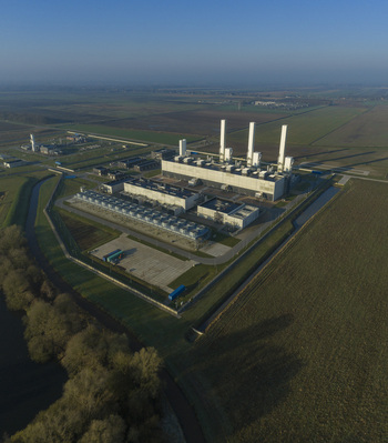 Aerial view of the nitrogen plant with tall white chimneys and industrial buildings surrounded by flat agricultural fields under a clear blue sky in Zuidbroek Groningen Netherlands. Aerial view of the nitrogen plant with tall white chimneys and industrial buildings surrounded by flat agricultural fields under a clear blue sky in Zuidbroek Groningen Netherlands.