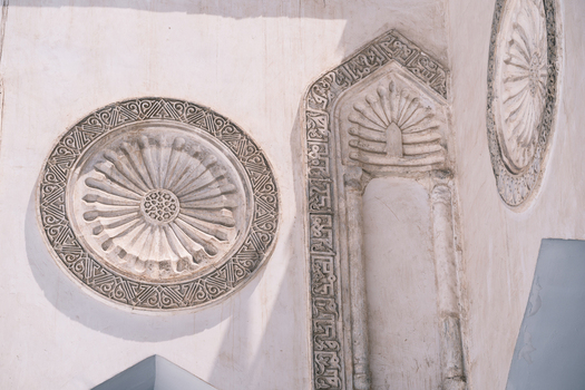 View of intricate stone carvings and circular medallions on the historic walls of Al Azhar Mosque in Cairo Egypt. View of intricate stone carvings and circular medallions on the historic walls of Al Azhar Mosque in Cairo Egypt.