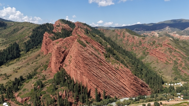 Aerial view of the striking red sandstone rock formations of Jety Oguz surrounded by lush pine forests and rolling hills in Jety Oguz Issyk Kul Region Kyrgyzstan. Aerial view of the striking red sandstone rock formations of Jety Oguz surrounded by lush pine forests and rolling hills in Jety Oguz Issyk Kul Region Kyrgyzstan.