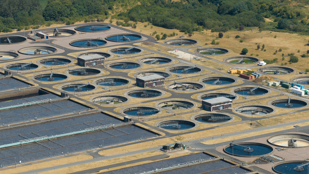 Aerial view of the Severn Trent Water Minworth sewage treatment works featuring numerous circular sedimentation tanks and large rectangular basins in Birmingham England United Kingdom. Aerial view of the Severn Trent Water Minworth sewage treatment works featuring numerous circular sedimentation tanks and large rectangular basins in Birmingham England United Kingdom.
