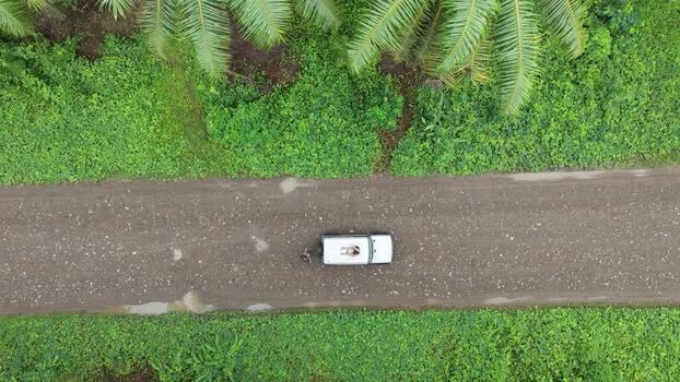 Aerial view of a white vehicle on a dirt road in Costa Rica. Aerial view of a white vehicle on a dirt road in Costa Rica.