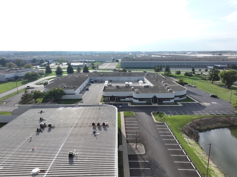 Aerial view of an industrial complex featuring flat roofed buildings parking lots and a small pond in Indianapolis Indiana United States. Aerial view of an industrial complex featuring flat roofed buildings parking lots and a small pond in Indianapolis Indiana United States.
