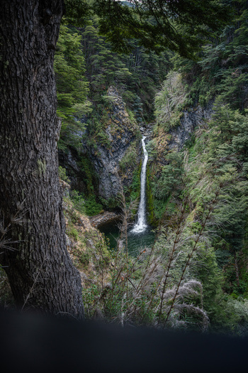 View of Waterfall Rio Bonito cascading down rocky cliffs surrounded by lush forest in Los Lagos Department Neuquen Province Argentina. View of Waterfall Rio Bonito cascading down rocky cliffs surrounded by lush forest in Los Lagos Department Neuquen Province Argentina.